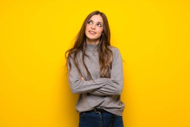 Genç kadın gülümseyerek süre ararken sarı duvarın üzerinden