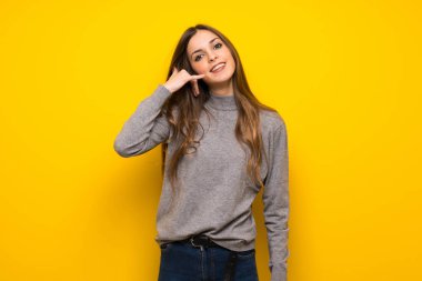 Genç kadın telefon jest yaparak sarı duvarın üzerinden. Bana arka işareti de
