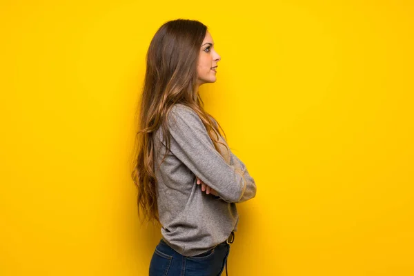 Jovem Mulher Sobre Parede Amarela Posição Lateral — Fotografia de Stock