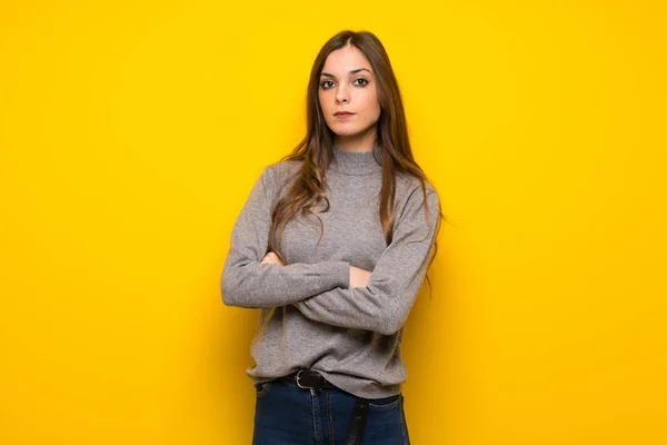 Young woman over yellow wall portrait