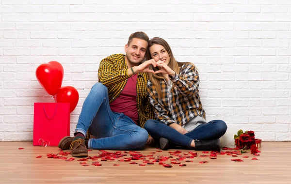 室内で手でハートを作るがバレンタインの日のカップル — ストック写真