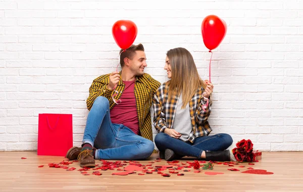 バレンタインデーにハートの風船で屋内でカップル — ストック写真