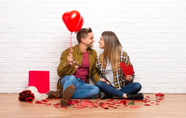 一对在情人节在室内拿着心脏符号和气球的夫妇 — 图库照片