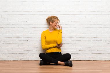 Tatlı bir ifadeyle gülümseyen katta oturan genç kız