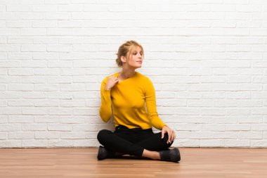 Yorgun ve hasta ifade ile katta oturan genç kız