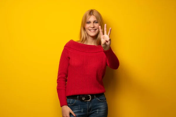 Blond Žena Přes Žlutou Zeď Šťastná Počítání Tři Prsty — Stock fotografie