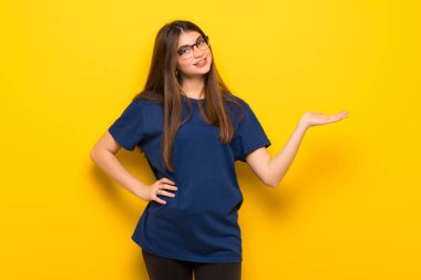 Genç kadın boşaltmak hayali avuç içinde tutan sarı duvarın üzerinden gözlüklü bir reklam eklemek için