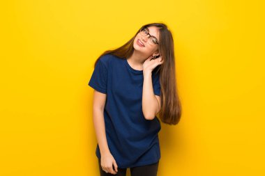 Bir şey kulak el koyarak dinleme sarı duvarın üzerinden gözlüklü genç kadın