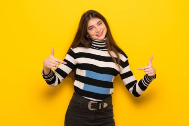 Sarı duvar gurur ve halinden memnun içinde genç kadın kendine kavram seviyorum