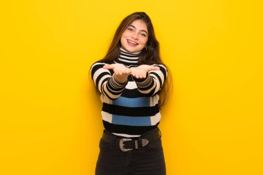 Genç kadın boşaltmak hayali avuç içinde tutan sarı duvarın üzerinden bir reklam eklemek için