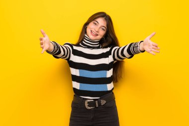 Sunulması ve el ile gelmek davet sarı duvarın üzerinden genç kadın