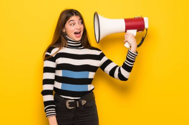 Çok gürültü yapar bir megafon alarak sarı duvarın üzerinden genç kadın