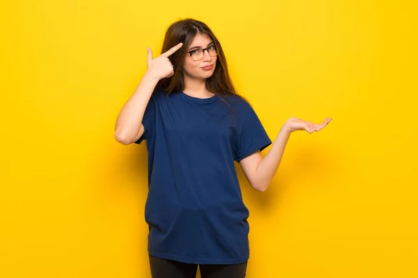 Mujer Joven Con Gafas Sobre Pared Amarilla Haciendo Gesto Locura —  Fotos de Stock