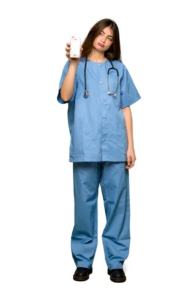 分離の白い背景の上の壊れた携帯電話で看護師の若いのフルレングスのショット — ストック写真