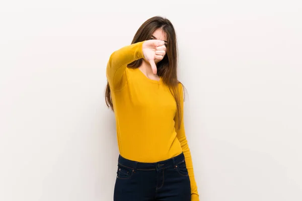 負の式と記号を親指を示す黄色のセーターを持つ若い女性 — ストック写真