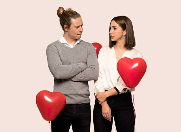 Couple in valentine day with confuse face expression while bites lip over isolated background