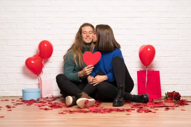 İki kalp simgesi tutan ve öpüşme valentines gün içinde