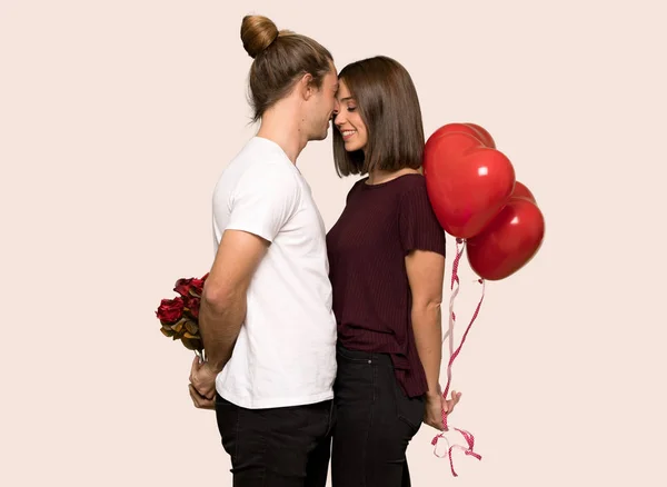 一对在情人节拿着心脏标志和气球在孤立的背景 — 图库照片