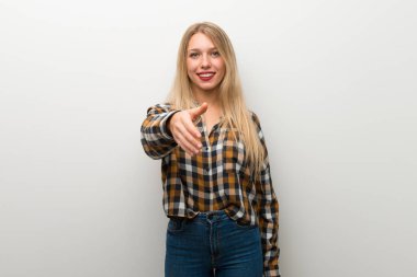 Sarışın genç kız iyi bir anlaşma kapanış için el sıkışan beyaz duvar üzerinde