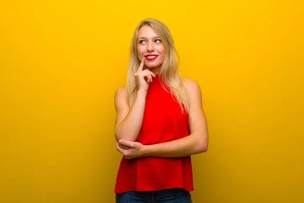 Ung Flicka Med Röd Klänning Över Gul Vägg Tänkande Idé — Stockfoto