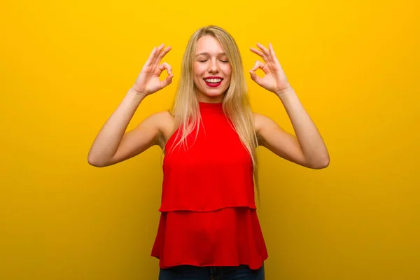 Chica Joven Con Vestido Rojo Sobre Pared Amarilla Pose Zen —  Fotos de Stock