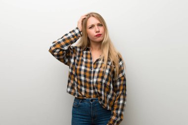 Sarışın genç kız hayal kırıklığı ve anlayış değil bir ifade ile beyaz duvar üzerinde