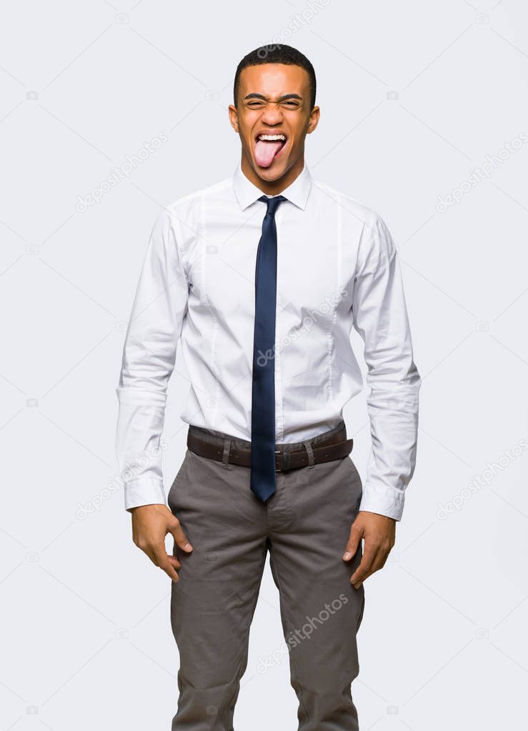 Young afro american businessman showing tongue at the camera having funny look on isolated background
