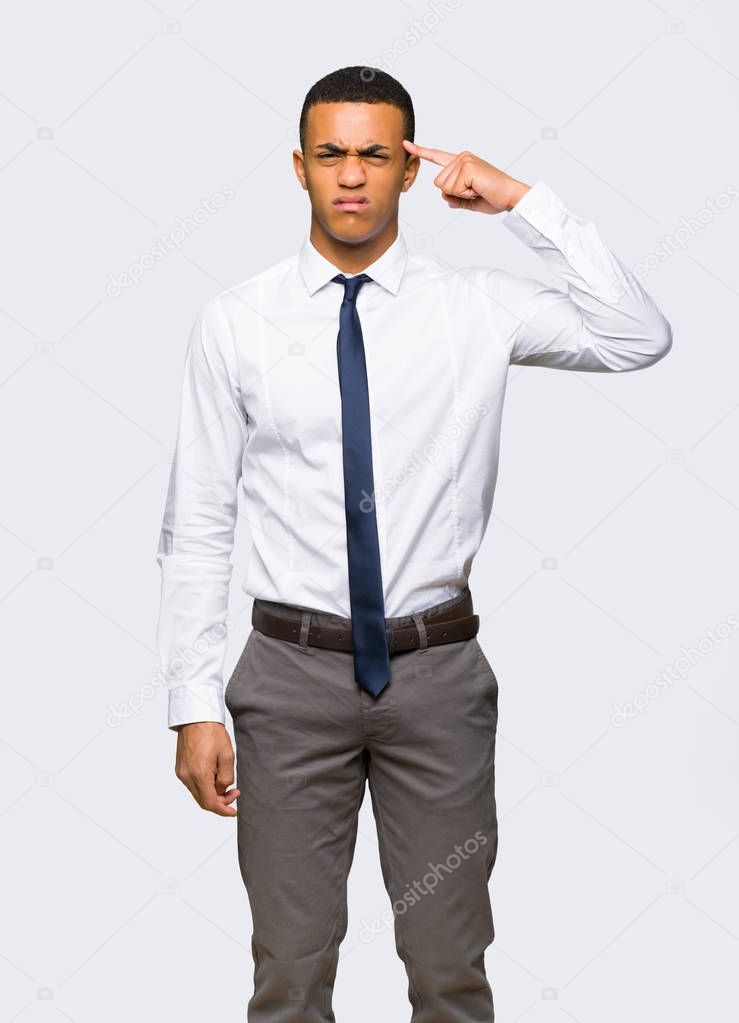Young afro american businessman making the gesture of madness putting finger on the head on isolated background