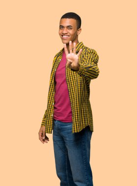 Genç afro Amerikalı adam mutlu ve sayım dört parmaklı izole arka plan üzerinde