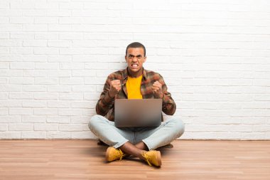 Diz üstü tarafından kötü bir durum hayal kırıklığına ile katta oturan Afrikalı-Amerikalı adam