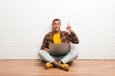 Afrika kökenli Amerikalı adam onun niyetiyle laptop ile katta oturan çözüm parmak kaldırma sırasında fark eder