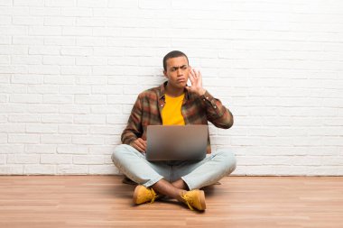 Afrika kökenli Amerikalı adam için bir şey kulak el koyarak dinleme onun laptop ile katta oturan
