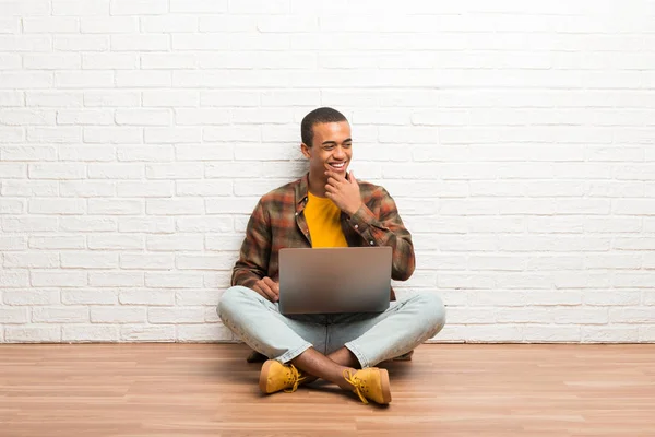 Hombre Afroamericano Sentado Suelo Con Portátil Mirando Hacia Lado Con — Foto de Stock