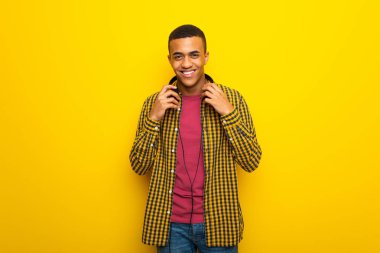 Kulaklık sarı zemin üzerine genç afro Amerikalı adam