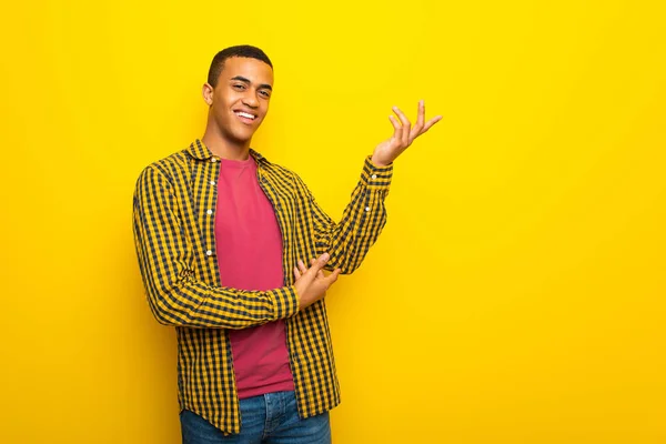 Giovane Afro Americano Uomo Sfondo Giallo Che Estende Mani Lato — Foto Stock