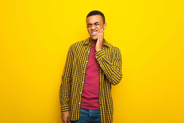 歯痛と黄色の背景に若いアフロ アメリカ人 — ストック写真