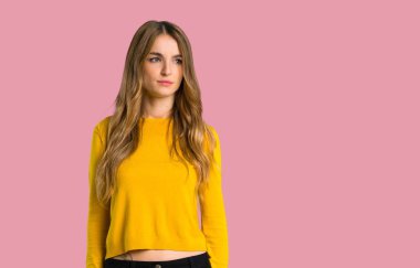 sarı kazak duygu üzgün izole pembe bir arka plan üzerinde genç kızla