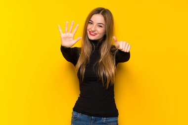Altı parmaklı sayma sarı arka plan genç güzel kadın