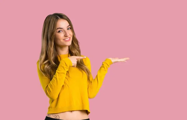 Giovane Ragazza Con Maglione Giallo Che Tiene Copyspace Immaginario Sul — Foto Stock