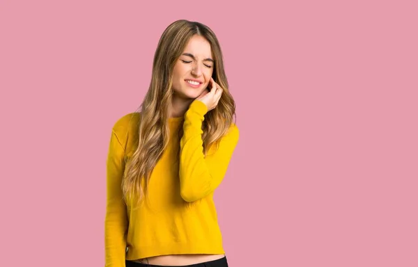 歯痛分離のピンクの背景に黄色のセーターを持つ少女 — ストック写真