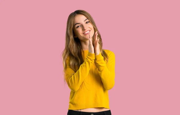 黄色いセーターを着て分離ピンク背景に会議でのプレゼンテーションの後 拍手を持つ少女 — ストック写真