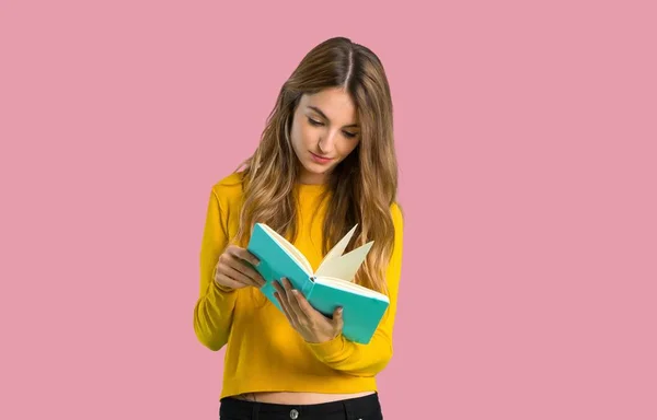 Jovem Com Suéter Amarelo Segurando Livro Apreciando Leitura Fundo Rosa — Fotografia de Stock