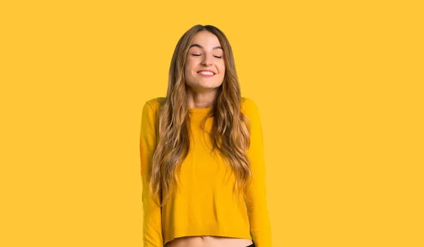 年轻的女孩与黄色毛衣高兴和微笑在被隔绝的黄色背景 — 图库照片