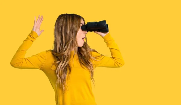 Young Girl Yellow Sweater Looking Distance Binoculars Isolated Yellow Background — Stock Photo, Image