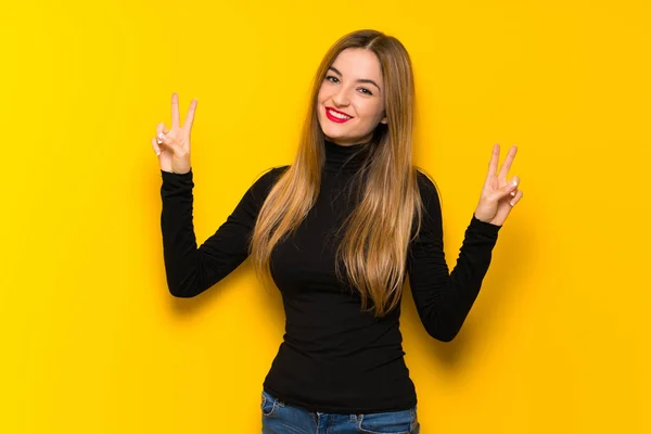 Joven Mujer Bonita Sobre Fondo Amarillo Sonriendo Mostrando Signo Victoria —  Fotos de Stock