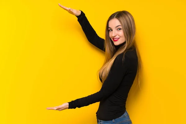 Junge Hübsche Frau Auf Gelbem Hintergrund Hält Copyspace Eine Anzeige — Stockfoto