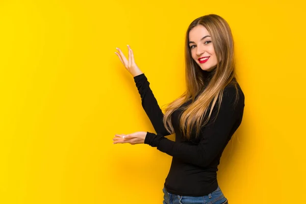 若いきれいな女性に来て招待側に手を拡張する黄色の背景に — ストック写真