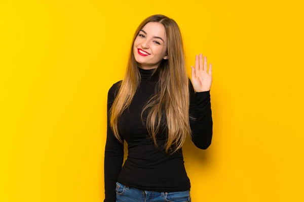 Junge Hübsche Frau Auf Gelbem Hintergrund Salutiert Mit Fröhlichem Gesichtsausdruck — Stockfoto