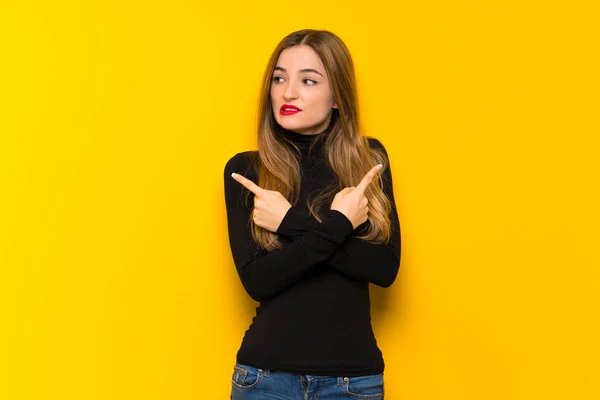 Jovem Mulher Bonita Sobre Fundo Amarelo Apontando Para Laterais Com — Fotografia de Stock