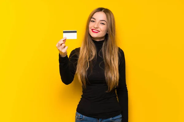 Jovem Mulher Bonita Sobre Fundo Amarelo Segurando Cartão Crédito — Fotografia de Stock
